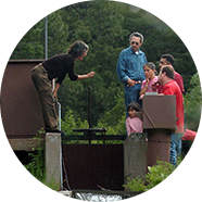 Woman and family examining an acequia.