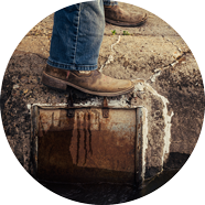 Person using foot to close an irrigation gate.